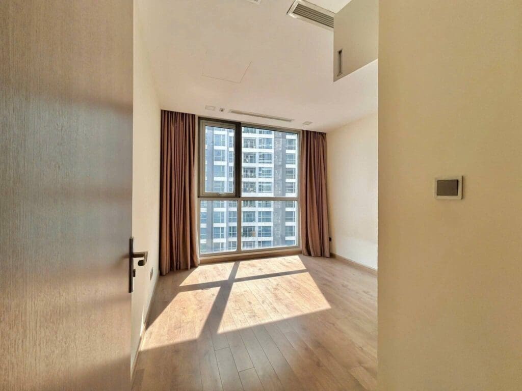 Phòng ngủ căn hộ vinhomes lót sàn gỗ có cửa sổ lớn